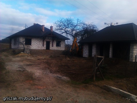 Dom z garażem w trakcie spychania ziemi.