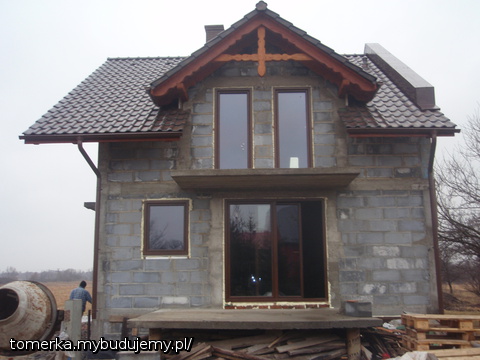 Widok na okno w salonie , a na poddaszu okna w sypialniach