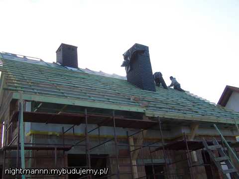 Kominy też już się pojawiły, a w tle widac poczynania dekarzy przy układaniu membrany i łaceniu jej